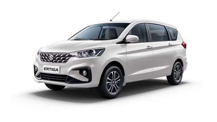 White Suzuki Ertiga SUV from the AV Travels fleet parked in three quarter view